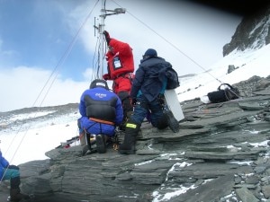 Il posizionamento della stazione meteo a Colle Sud ripresa in diretta web da Montagna.tv