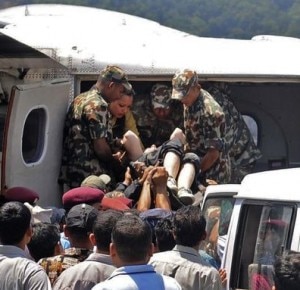 I militari nepalesi caricano uno dei sopravvissuti sull'aereo che lo porterà in ospedale ( Krishnamani Baral / AP Photo)