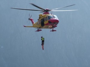 Elicottero cala con il verricello un soccorritore durante un intervento di soccorso (Photo courtesy of www.ilgiornaledellaprotezionecivile.it)