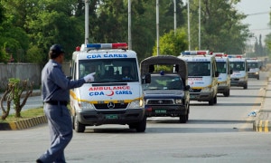A traffic warden guides ambulances carrying the bodies of foreign tourists killed by unidentified gunmen near the Nanga Parbat peak, after they are brought to a military base in Rawalpindi June 23, 2013. Photo: Reuters