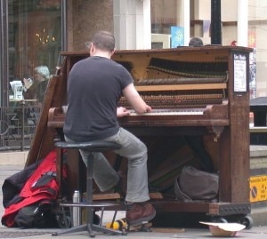 Pianista suona tra le strade di una città (Photo courtesy of Wikimedia Commons)