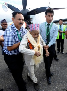 In this file photo, Bote Rai (C), 106, receives assistance on the tarmac after flying for the first time during his arrival at the Kathmandu airport on August 20, 2013. File Photo: AFP