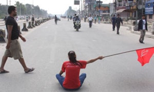 A cadre of the CPN-Maoist, one of the major bandh enforcer sits at the middle of the road to obstruct vehicular movement in Kathmandu. The party along with other 32 parties has called for shutdown strike  on Thursday, September 12, 2013. Photo: NMF