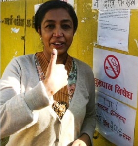 A woman points out a mark at her finger as a proof for casting a vote. Photo: NMF