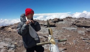 This photo released by Lhawang Dhondup shows 9-year-old Tyler Armstrong standing by a cross on the summit of the 22,841-foot Aconcagua Mountain in Argentina on Tuesday. Source: AP 