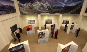 Visitors look at photos at the "Climate Change" exhibition.