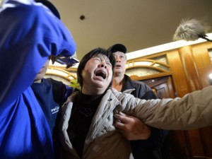 A relative (C) of passengers on Malaysia Airlines flight MH370 cries after hearing the news that the plane plunged into Indian Ocean at a hotel in Beijing on March 24, 2014.    AFP PHOTO 