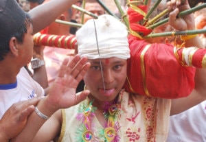 Juju Bhai Shrestha, who got his tongue pierced for the 6th  consecutive year as part of a Newari tradition, waves to his supporters during the religious procession on the sixth day of Bisket Jatra. Image: Agency