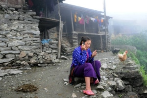  a woman in Haku village in Rasuwa district talks on her mobile phone. Once affordable only for the wealthy, over the past few years mobile phones have become cheaper and more available. Image credit to Chandra Shekhar Karki.