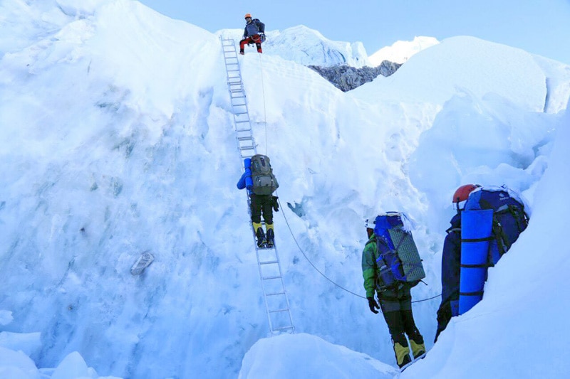 Climber tries to walk past the ladder while ascending to Mt Everest, on Monday, May 9, 2016.