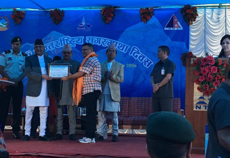 Prime Minister KP Sharma Oli honouring Damber Parajuli, President of Expedition Operator Association of Nepal, for coordinating rope fixing task on Mt Everest, on the occasion of International Mt Everest Day, in Kathmandu, on Sunday, May 29, 2016. Photo: THT