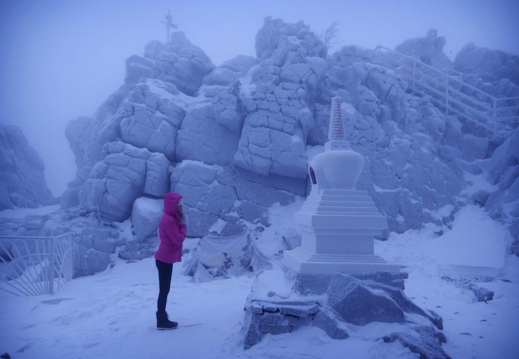 Un novizio buddista prega  davanti allo stup del monastero, o “shrine”