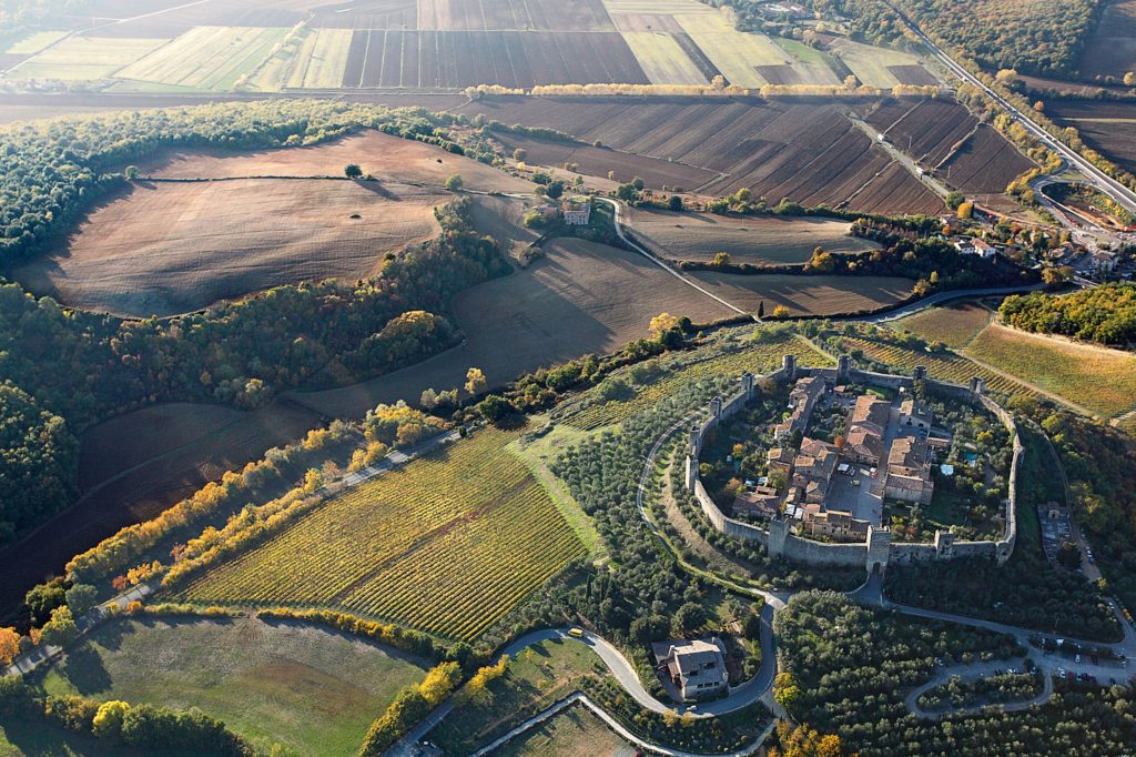 La cinta muraria di Monteriggioni abbraccia la sommità del colle e, rafforzata da 14 torri squadrate e sporgenti all’esterno, si sviluppa per quasi 600 metri.