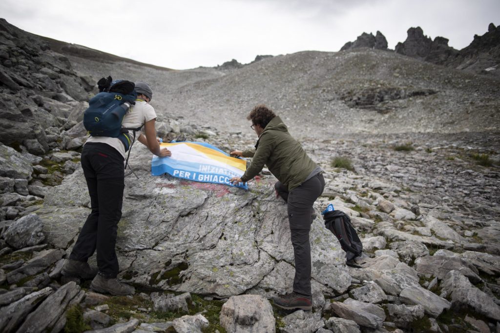 Due ambientalisti distendono una bandiera durante la commemorazione del ghiacciaio Pizol - Foto ANSA