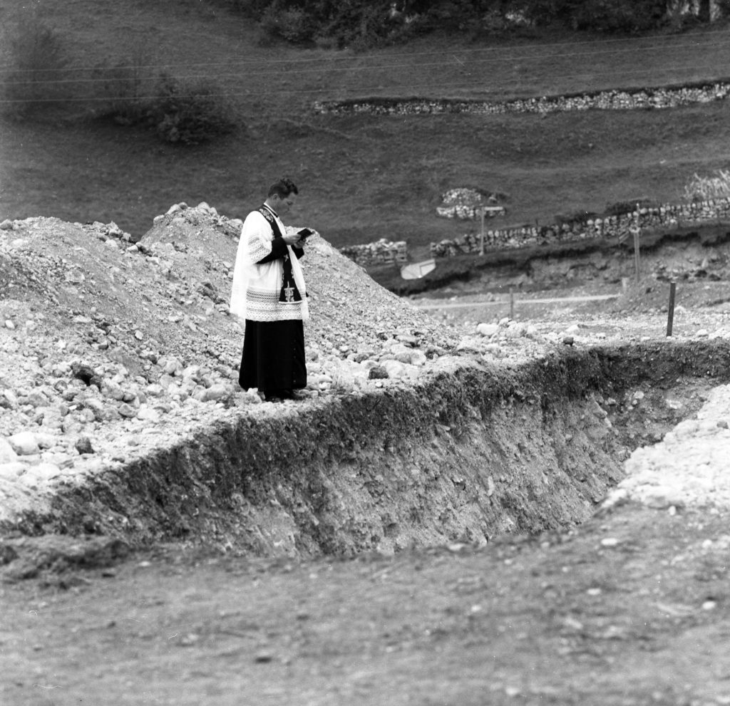 Un sacerdote prega tra le macerie a Longarone, uno dei paesi distrutti nella tragedia del Vajont