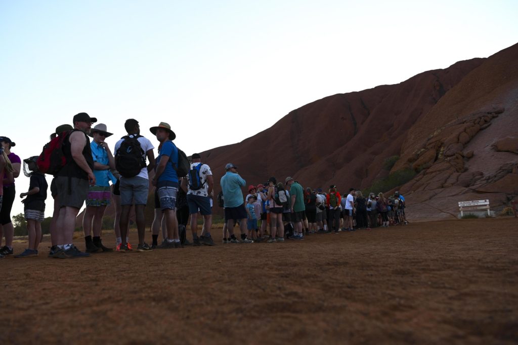 La fila interminabile di curiosi alla base del monolite di Uluru - Foto ANSA/EPA/LUKAS COCH AUSTRALIA AND NEW ZEALAND OUT