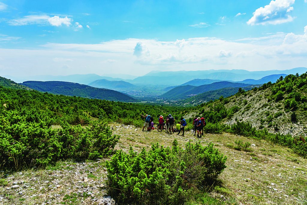  Camminatori in discesa
dal Passo Le Forche verso Santa Maria in Valle Porclaneta,
con vista su Rosciolo, Magliano de’ Marsi e i Piani Palentini. Foto @ Rinaldo Gabbianelli 