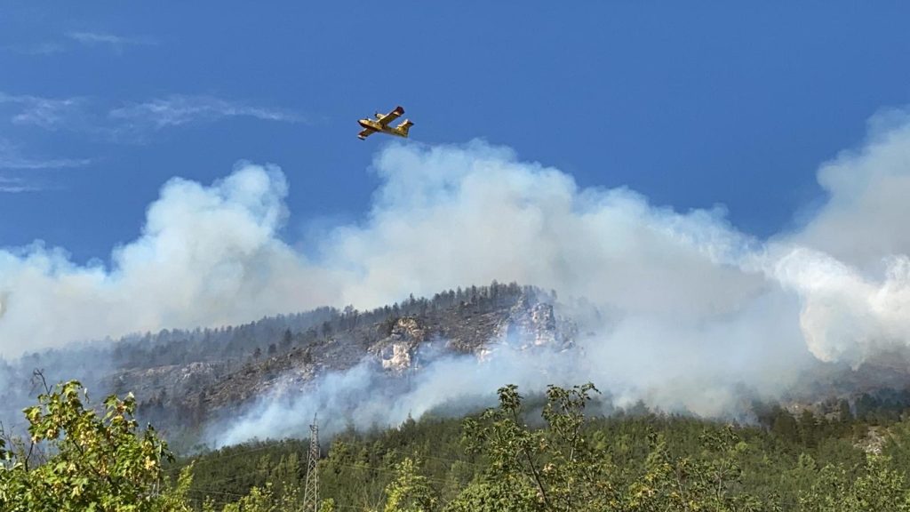 Un canadair in volo sulle fiamme -
ANSA/ GERMANA D