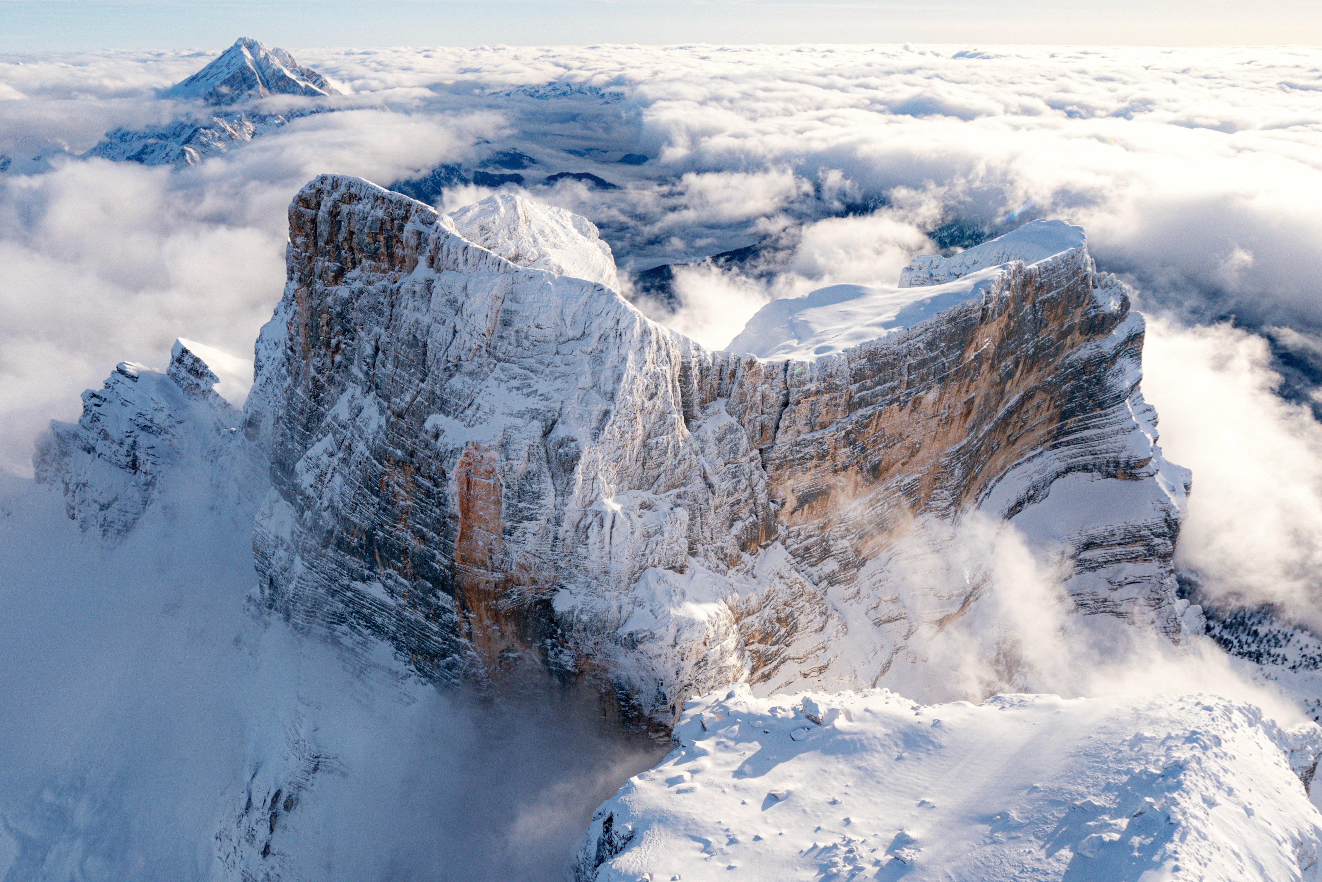 Una veduta aerea del Pelmo (3168 m), il solitario massiccio delle Dolomiti di Zoldo
che si staglia a sud di Cortina, tra la Valle del Boite e la Val di Zoldo. Come si intuisce dall’immagine, sul versante meridionale della montagna si apre un vasto catino roccioso, dove sale la via Normale, percorsa per la prima volta dall’irlandese John
Ball il 19 settembre 1857, anche se la cima era già stata raggiunta, con tutta probabilità, da cacciatori locali. Foto @ R. Moiola