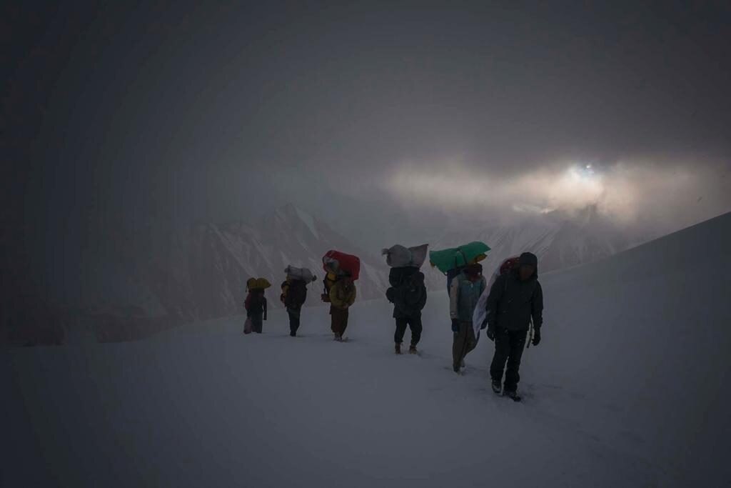Portatori salgono nella tormenta sul ghiacciaio Baltoro. Foto Paolo Petrignani