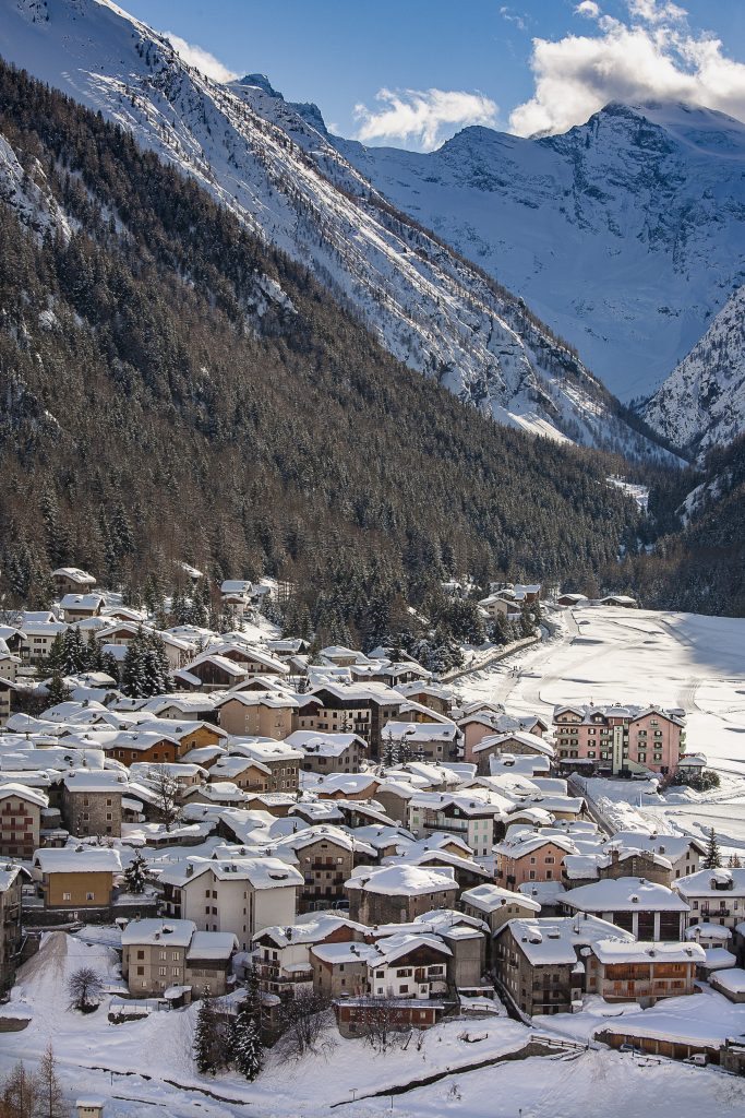 Le case di Cogne (a sinistra) contornano la prateria innevata di Sant’Orso, percorsa dalle piste di fondo. La grande casa rosa è l’hotel Bellevue. Foto @ Stefano Torrione