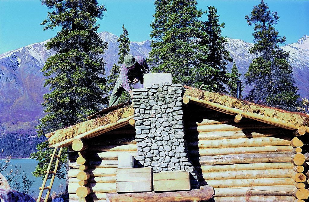 Il comignolo del camino in pietra ormai quasi completato. Foto 1973-1999 Richard Proenneke