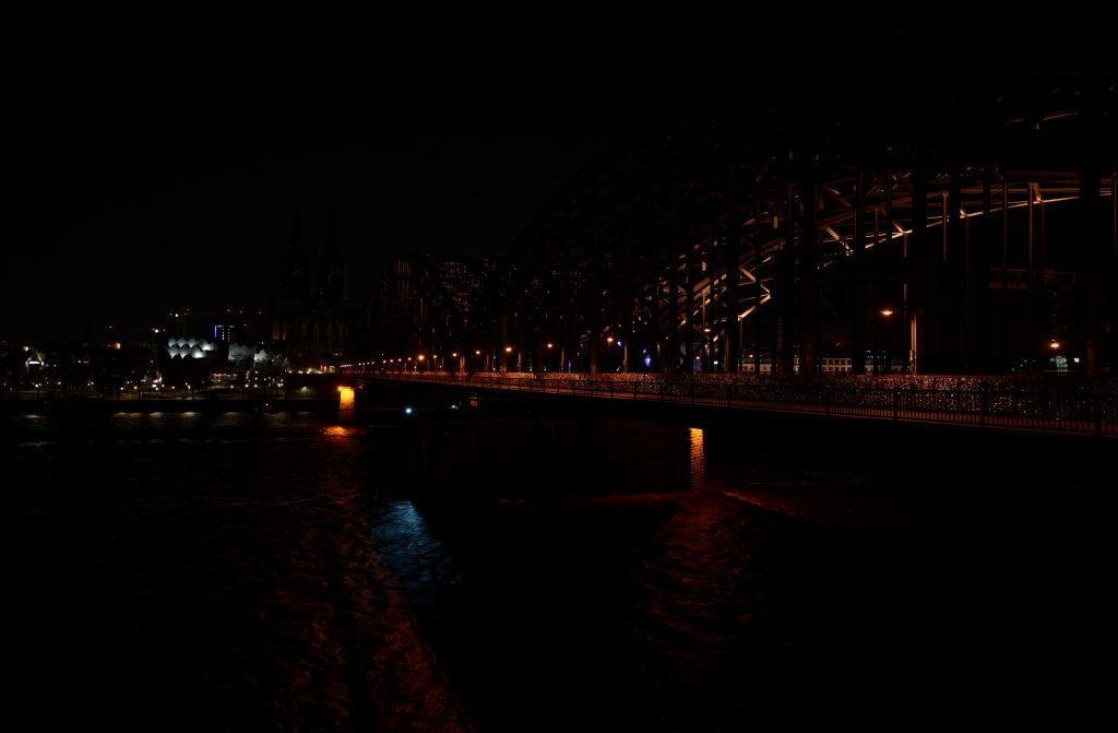 28 March 2020, North Rhine-Westphalia, Cologne: After switching off the lights of the cathedral and the Hohenzollern Bridge, the city centre is in darkness. During the worldwide campaign Earth Hour of the environmental organisation WWF, the lights on public buildings are switched off for one hour
