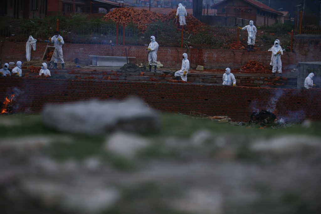 Si bruciano i morti di covi lungo le sponde del fiume Bagmati, a Kathmandu, vicino al Pashupathinath Temple. Foto @ ANSA
