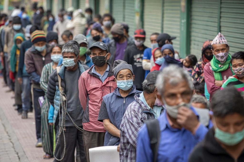 Il lockdown a Kathmandu, vuol dire anche tante difficoltà economiche per la popolazione. Nella foto nepalesi in coda per la razione di cibo giornaliera. Foto @ ANSA - EPA/NARENDRA SHRESTHA