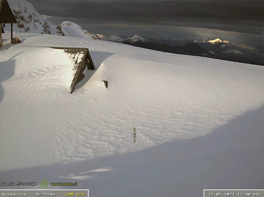 La webcam del rifugio della Kredarica-Triglav (Slo) alle 17.48 UTC (19.48 locali) del 23 maggio alla fine della nevicata che ha deposto 63 cm di neve fresca nelle precedenti 24 ore portando lo spessore al suolo a 510 cm, misura uguale al massimo stagionale 2020-21 misurato in precedenza anche il 24 gennaio 2021. Fonte https://www.arso.meteo.si