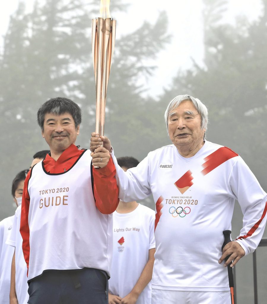 Yuichiro Miura e il figlio Gota con la torcia olimpica sul Fuji - Foto Japanese News