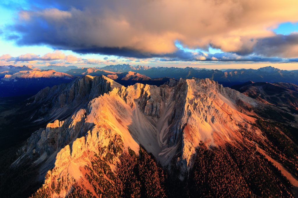 Al confine tra la Val di Fiemme e la Val d’Ega, il Latemar è spesso fotografato dal Lago di Carezza (qui, il versante di Obereggen), sul cui versante scende con una scenografica bastionata. In realtà si tratta di un gruppo complesso, a forma di ferro di cavallo, in cui si riconosce la forma di un antico atollo corallino. Foto @ Roberto Moiola/ClickAlps
