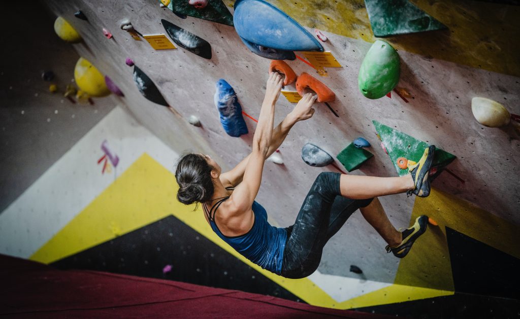 Bouldering in palestra su parete artificiale. Foto @ yns plt via unsplash