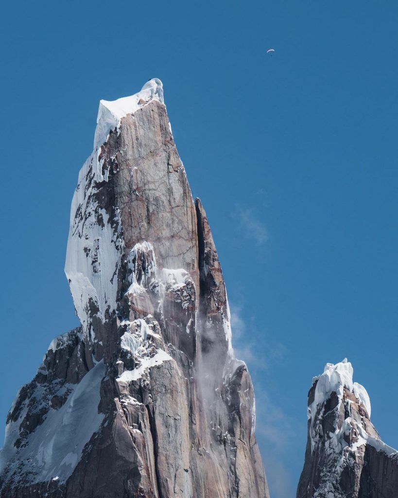 Il Cerro Torre, visibile in alto a destra la vela di un parapendio.  Foto instagram Roger Schäli