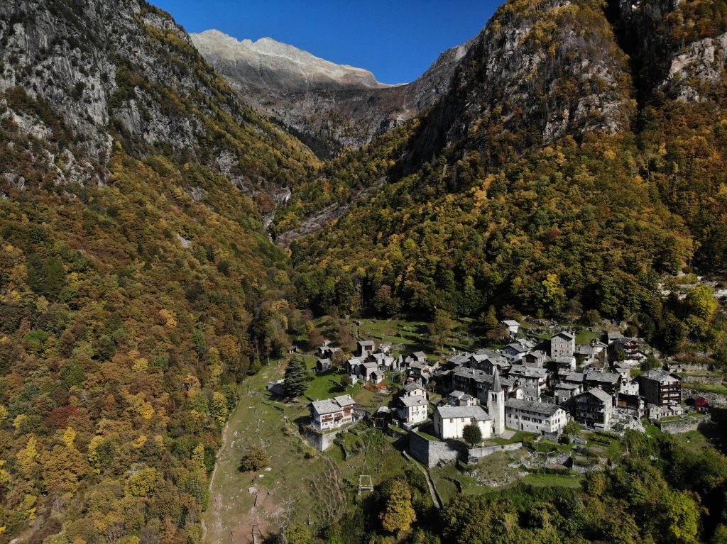 Vista su Savogno e sul vallone dell’Acquafraggia. Sotto, la canonica dove visse san Luigi Guanella dal 1867 al 1875.
A destra, il campanile della parrocchiale, di fine Quattrocento, e i bambini che suonano
le campane a mezzogiorno. Foto Umberto Isman