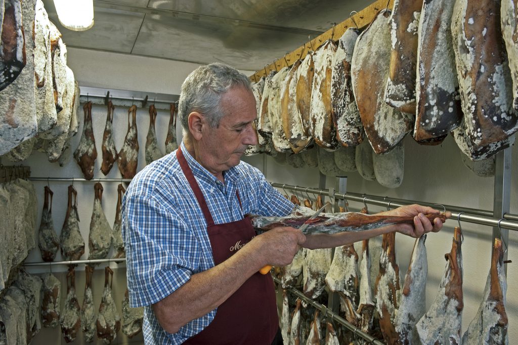 Aldo Del Curto alle prese con la tradizionale affettatura del violino di capra, nella sua macelleria di Chiavenna. Foto Livio Piatta