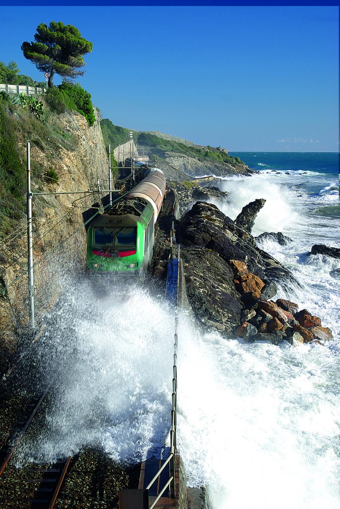 Un treno merci trainato da una moderna locomotiva francese in arrivo a Cervo. Spesso in lotta con le mareggiate, le rotaie costiere hanno svolto il proprio compito per quasi un secolo e mezzo, fino alla dismissione a fine 2016. Foto Dmytro Surkov/Adobe Stock