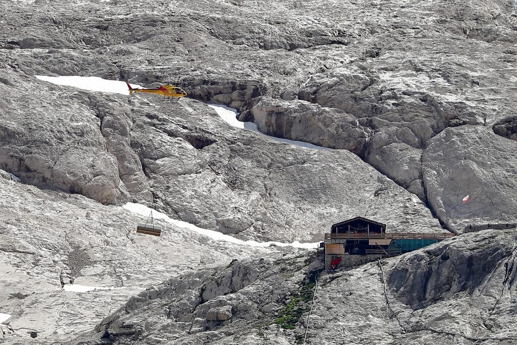 Un elicottero trasporta del materiale dal luogo coinvolto nella valanga sul ghiacciaio della Marmolada a Canazei, 05 luglio 2022. ANSA/ANDREA SOLERO