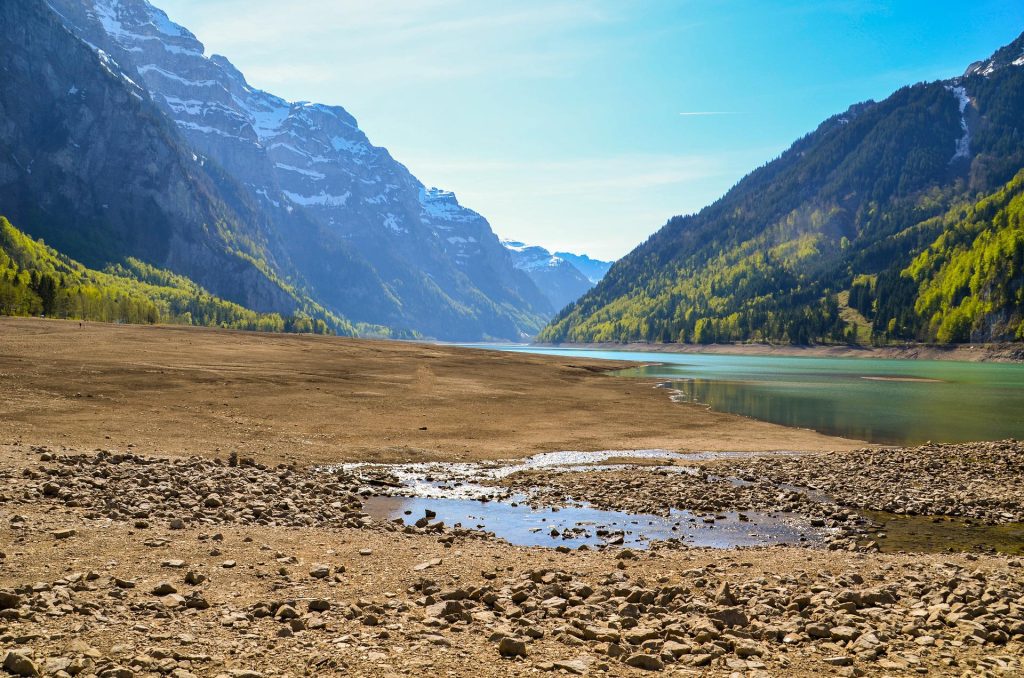 Un lago alpino con un basso livello idrico.