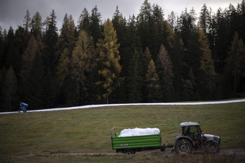 Un trattore porta la neve artificiale prodotta da una Snowfactory su una pista di sci di fondo a Lenzerheide, Svizzera. Foto EPA/GIAN EHRENZELLER/ANSA