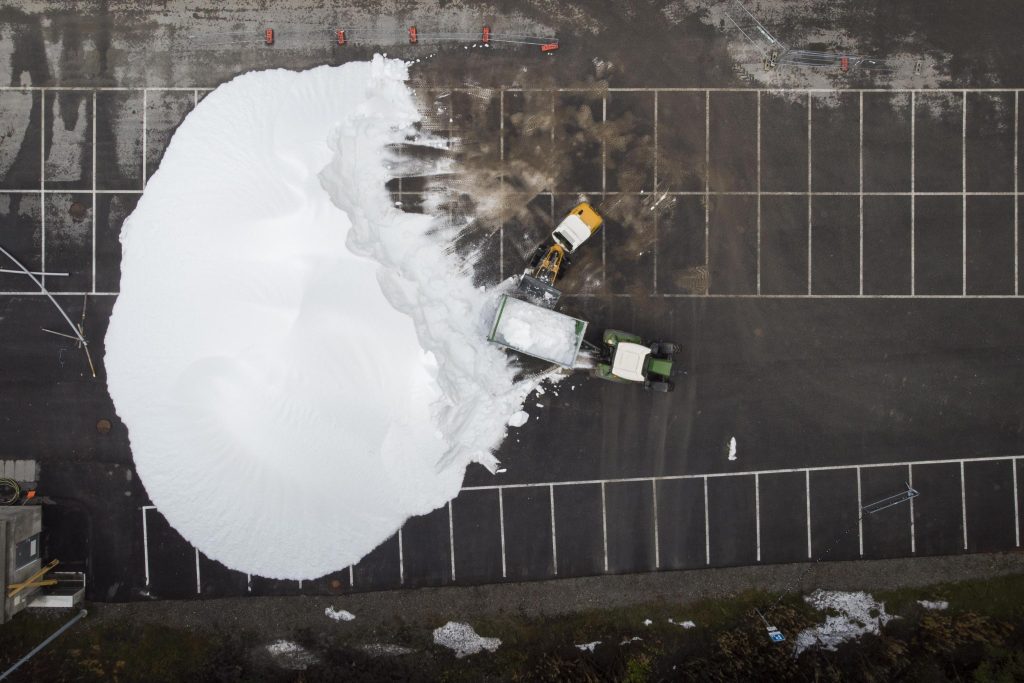 Un trattore porta la neve artificiale prodotta da una Snowfactory su una pista di sci di fondo a Lenzerheide, Svizzera. Foto EPA/GIAN EHRENZELLER/ANSA