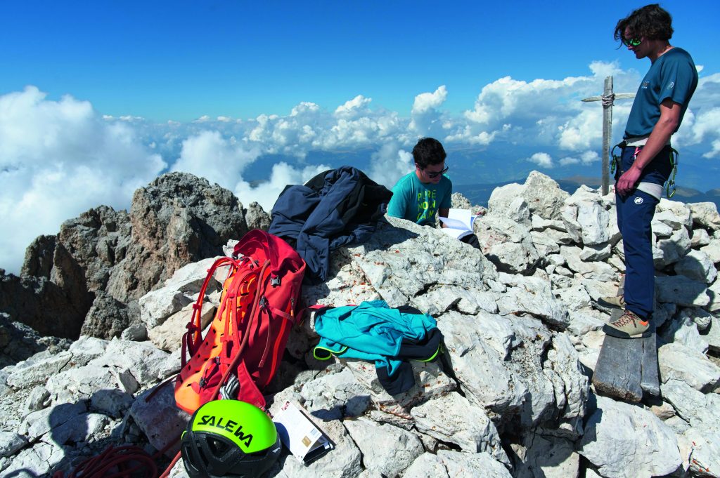 Le guide
Janluca Kostner
(in piedi) e Titus
Prinoth consultano
il libro di vetta. Foto Umberto Isman
