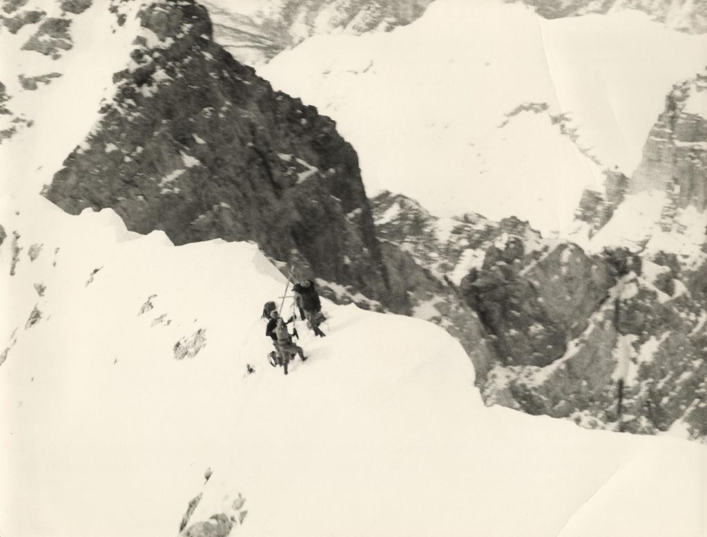 foto di Piussi, Hiebeler e Redaelli in vetta, tratta da un video realizzato da Furio Bianchet, allora presidente dal CAI Belluno, che si era fatto portare sulla parete con un aereo da turismo per seguire le fasi conclusive dell’ascensione.