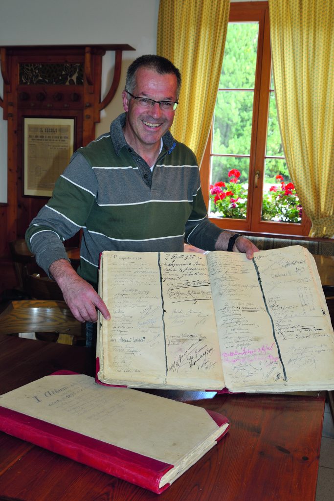 Narciso Salvadori, gestore del Rifugio dei Forni, mostra il libro del rifugio con la firma di Ardito Desio