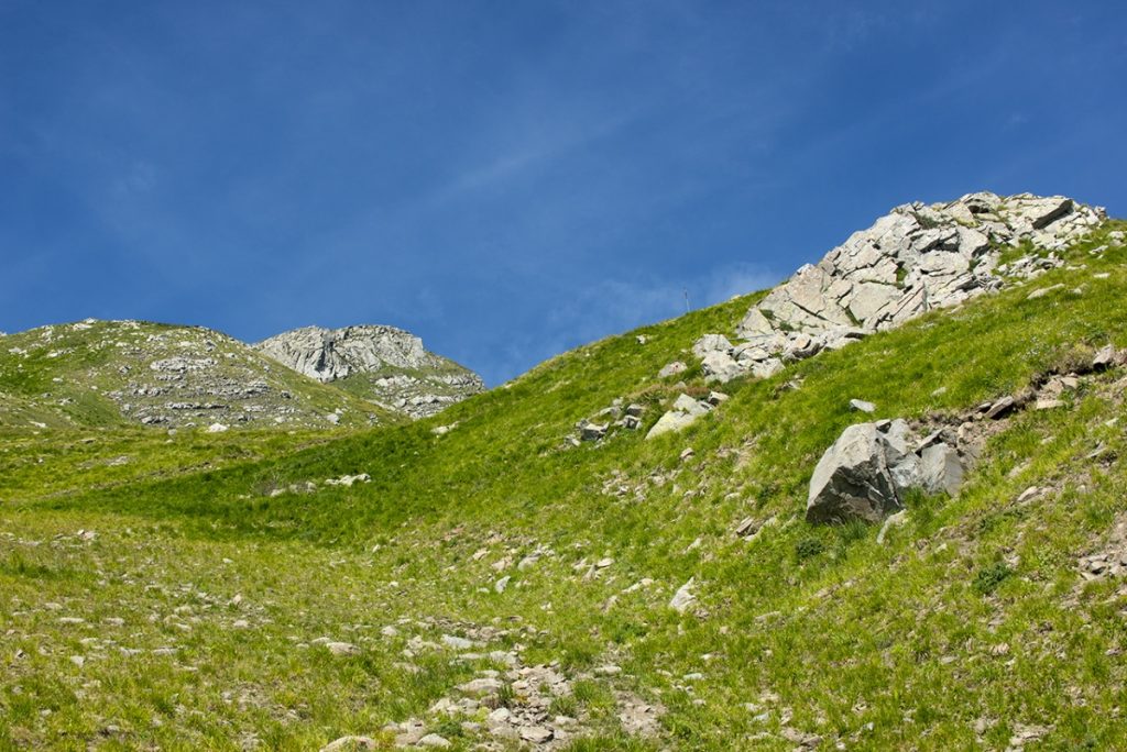 Il sentiero sale tra prati e rocce Foto Roberto Carnevali