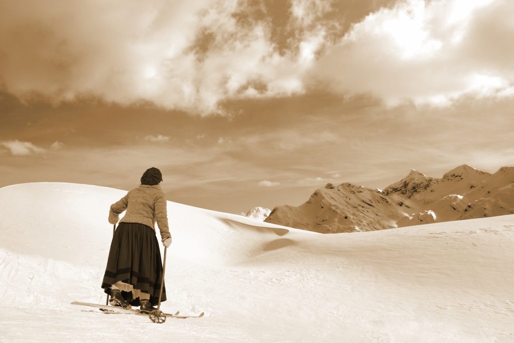Female Skier in a skirt and old wooden skis