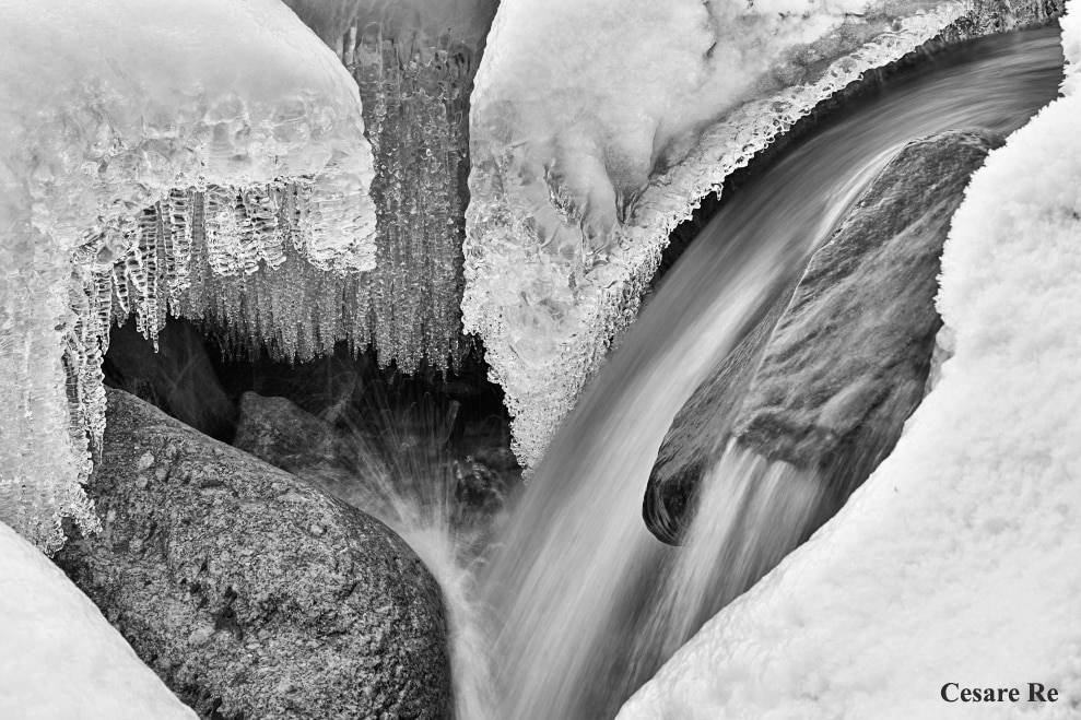 Anche il bianco e nero si presta molto per questo tipo di immagini, tra acqua, neve e ghiaccio. Nel torrente Anza, a Macugnaga. La cosa più complicata è stata piazzare il treppiede in una posizione stabile. La mia postura era talmente instabile da non riuscire neanche a posare lo zaino che è rimasto in spalla, mentre scattavo. Nikon D850; Nikkor 70-200 f4 AFG; 1/6 sec;   f/11; ISO 64. Conversione in bianco e nero, con Silver Efex Pro. 