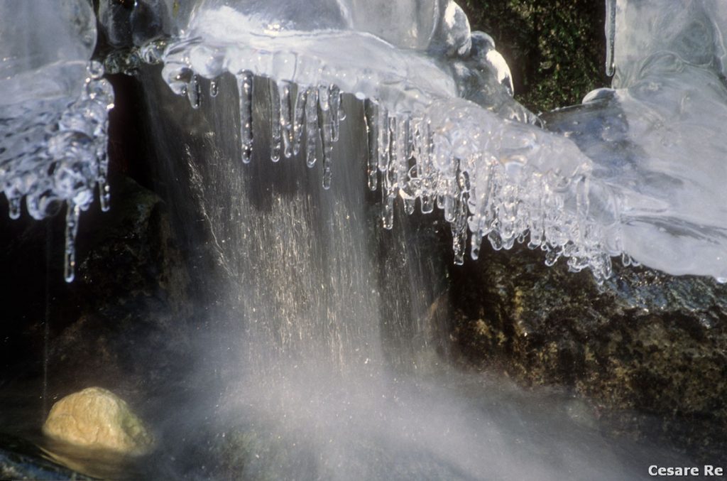 La contrapposizione tra mosso dell’acqua e fermo, del ghiaccio e della roccia gialla. Nel torrente Marmore, in Valtournenche, una parte di greto difficile da raggiungere. Sono sprofondato nella neve sino alla vita, per poi arrivare al livello dell’acqua. La cosa interessante è la forma effimera di questo arco di ghiaccio, caduto e frantumato, poco dopo il momento dello scatto. Nikon F5; Nikkor 80-200 2,8 AFD. Fujichrome Velvia 50; treppiede. Filtro ND 8 che ha tolto 3 stop, favorendo l’effetto seta, anche in piena luce.