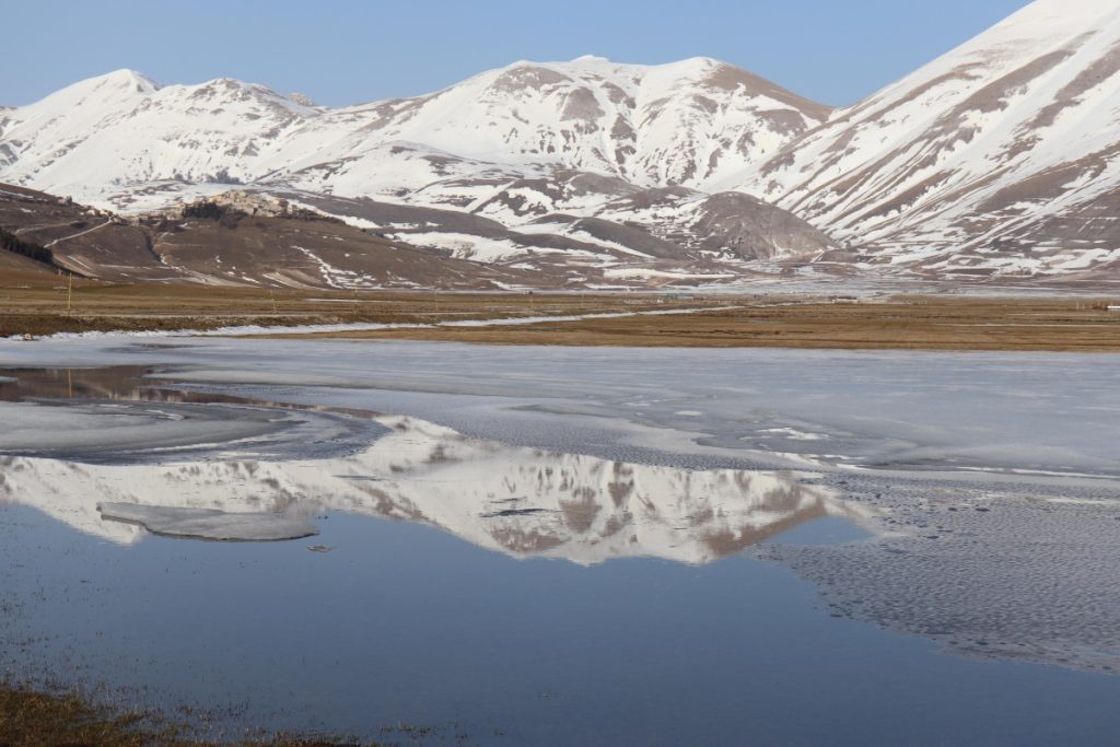 Castelluccio di Norcia si specchia nei laghetti formati dallo scioglimento della neve. Foto ANSA