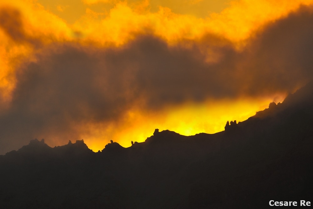 Il gruppo Umbrail, tra nubi di fuoco: a volte mi organizzo per scattare immagini ad un soggetto ben preciso. Studio l'orario giusto per essere sul posto, nel momento migliore. Il paesaggio di montagna, però, può essere imprevedibile, non irreggimentabile; la sua estetica è libera da schemi, così come la luce che accarezza le cime, con le nubi che giocano col cielo, rendendo quegli attimi unici e irripetibili, con foto molto diverse da quelle che avevo preventivato. Nikon D800; Nikkor 80-400 afg 4,5 / 5,6; iso 100; misurazione spot sulle nubi illuminate; 5,6 e 1/30 di secondo. Treppiede